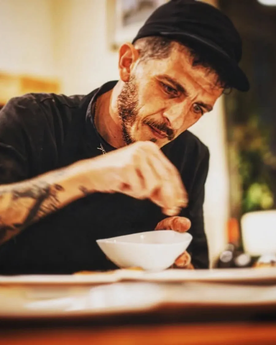 Marco Genna finishing a dish, seasoning by hand